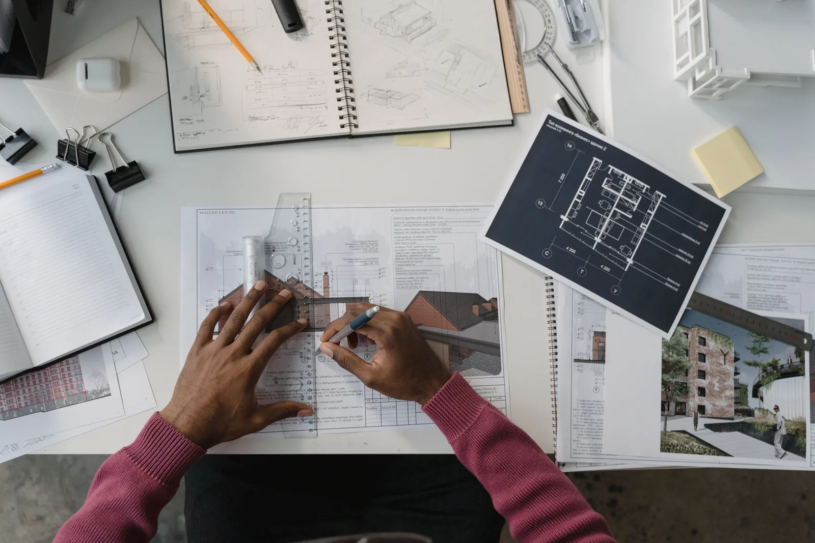 Overhead view of hands reviewing drawings and measurements