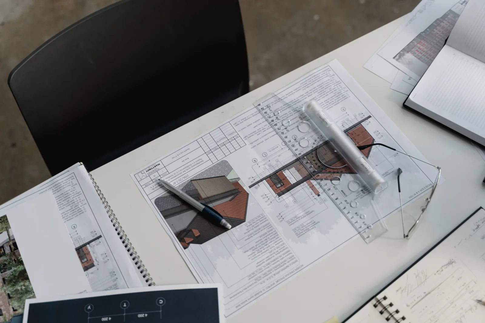 Planning reference documents and drafting tools on a desk