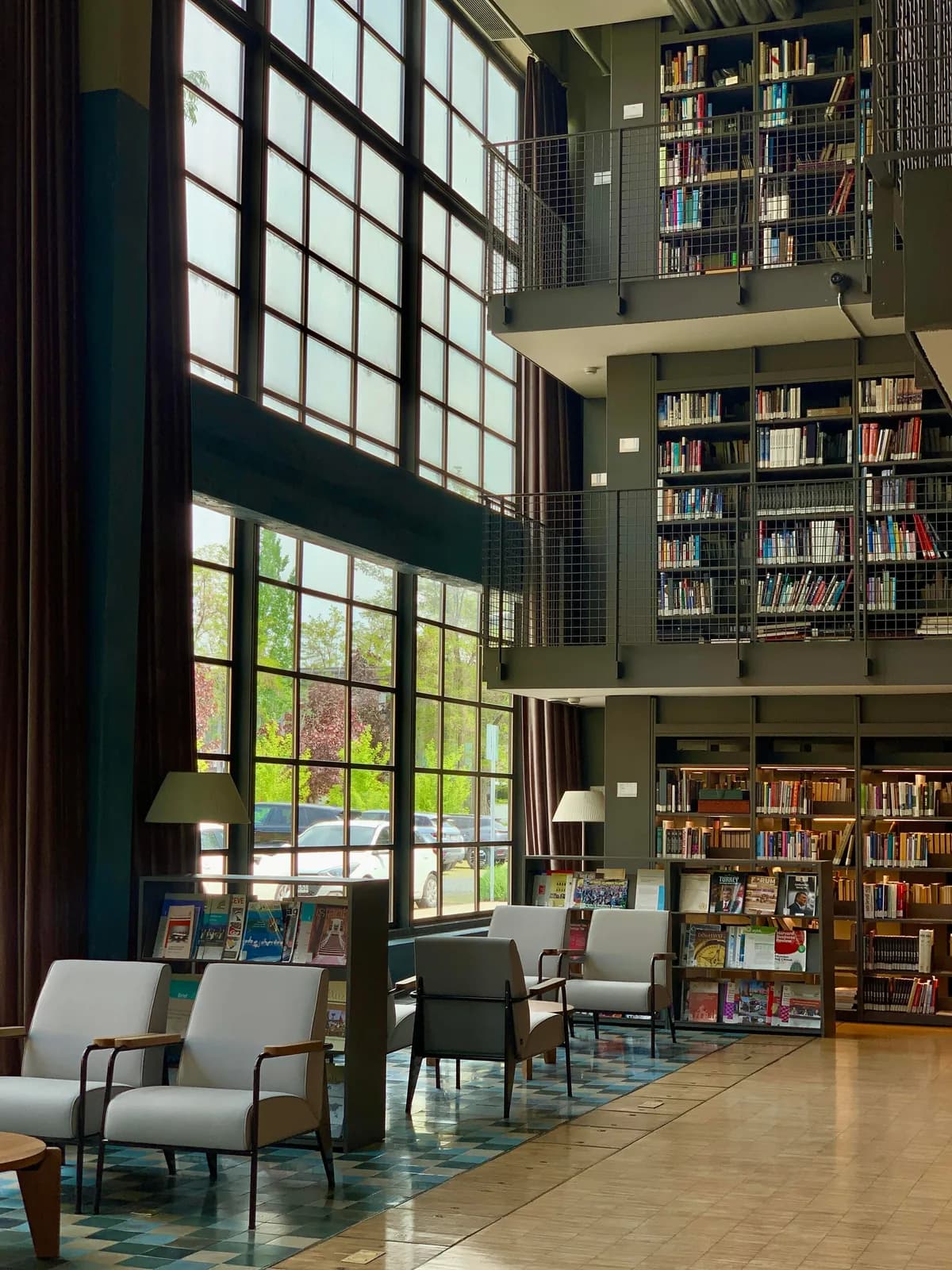 Library interior with reading spaces and tall windows